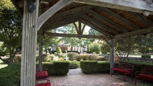 A covered outdoor seating area with benches and a fountain. - The Bykenhulle House (Hopewell Junction)