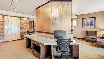 A modern hotel room with a desk, chair, and a large window.