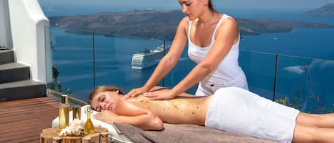 Une séance de massage sur une terrasse en bois offrant une vue imprenable sur l’océan.