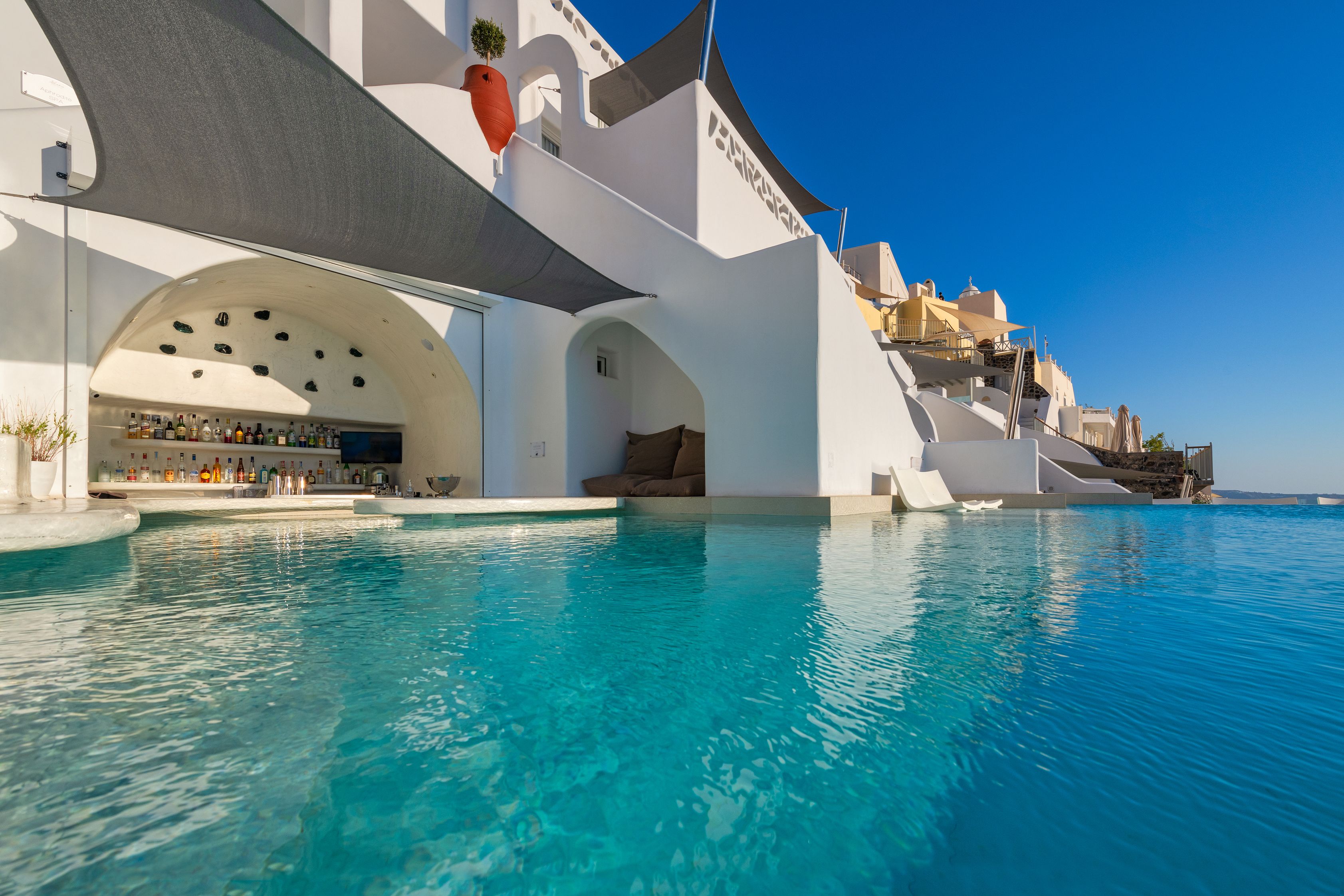 Un hotel moderno con piscina, arquitectura blanca y zona de bar.