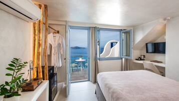 Una habitación de hotel moderna con balcón, cama, televisión y escritorio.