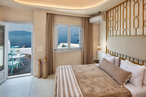A hotel room with a bed, a window with a view of the sea, a balcony with a table and chairs, and a decorative wall panel.