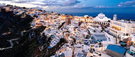 A coastal town with white buildings, a prominent church, and a view of the sea.