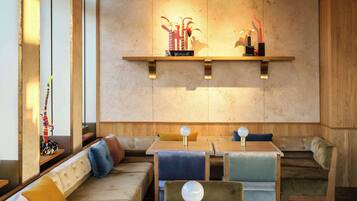 A modern interior with a wooden ceiling, built-in seating, and pendant lighting.