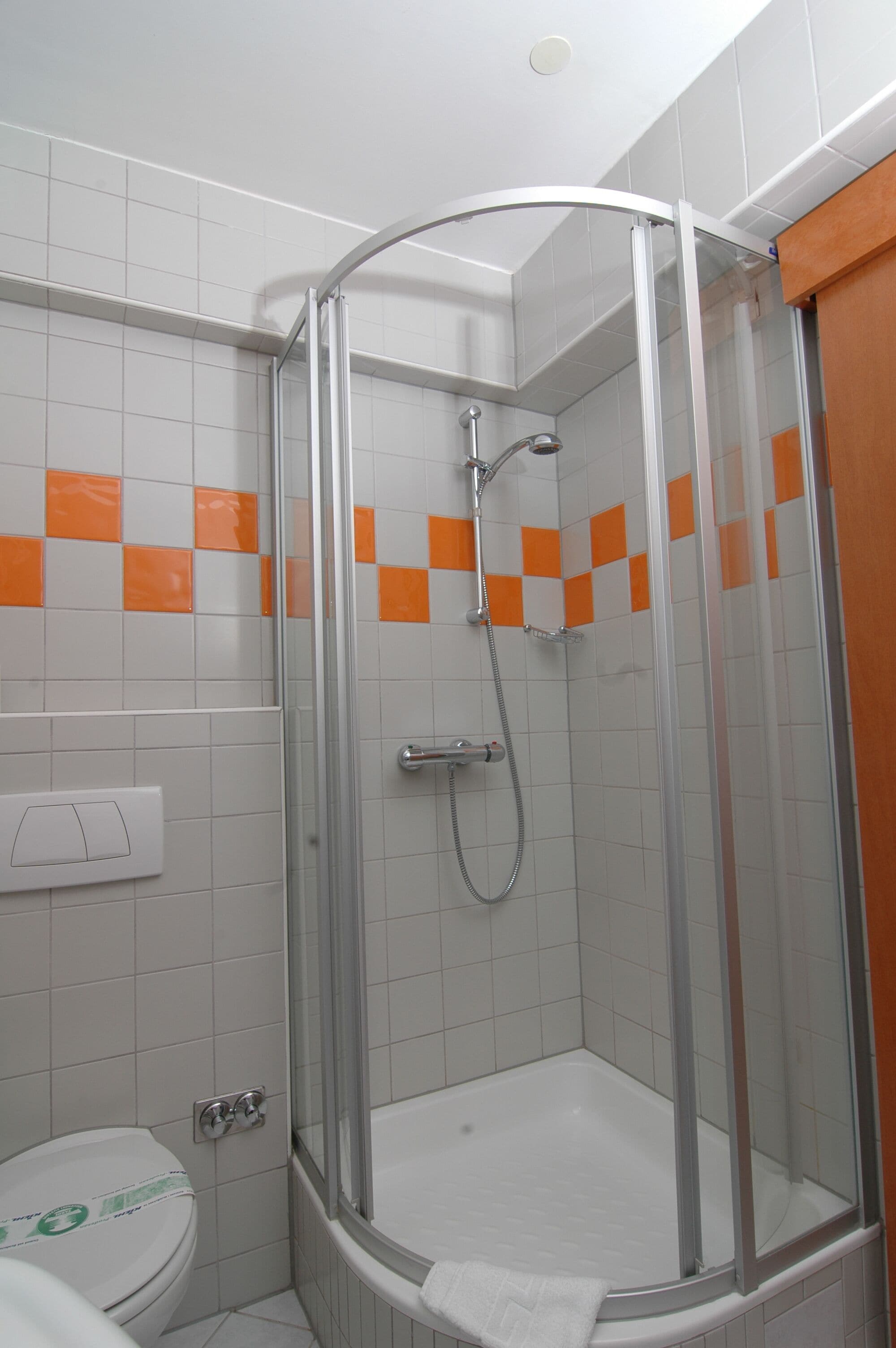 Un baño con ducha de mampara de vidrio, inodoro y bañera.
