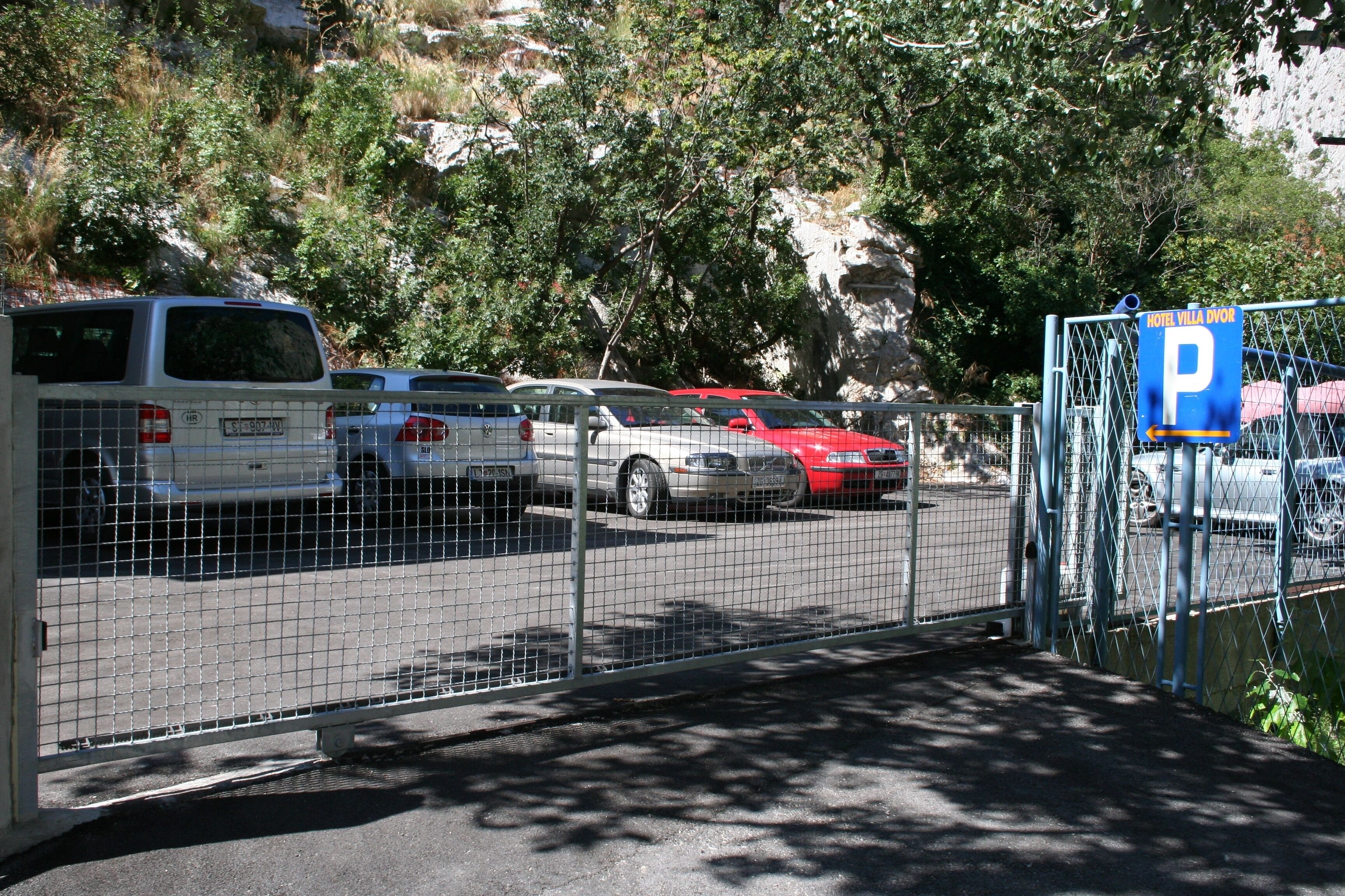 Un área de estacionamiento con un letrero azul que indica espacio para hotel.