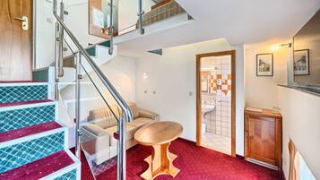 Un intérieur moderne avec un escalier, un canapé, une petite table et un meuble.