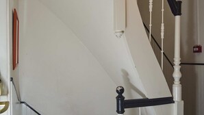 A white staircase with black handrails and a white banister. - ITC Hotel (Amsterdam)
