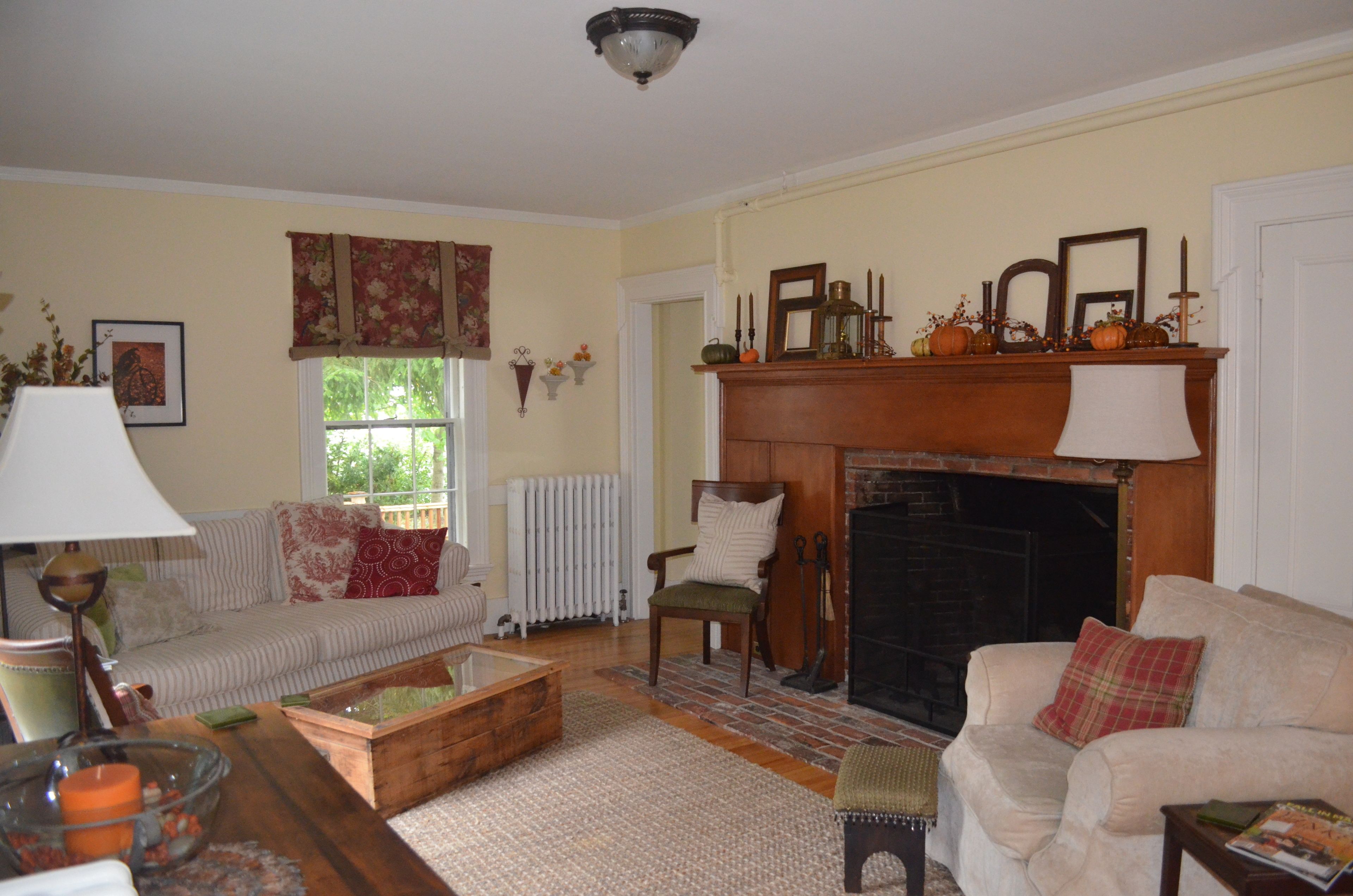 A cozy living room with a fireplace, a sofa, a chair, and a coffee table.