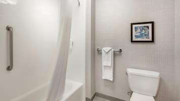 Een badkamer met een bad, toilet en een handdoekhouder.