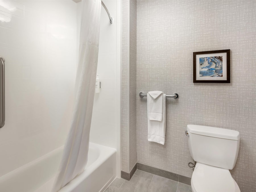 Een badkamer met een bad, toilet en een handdoekhouder.