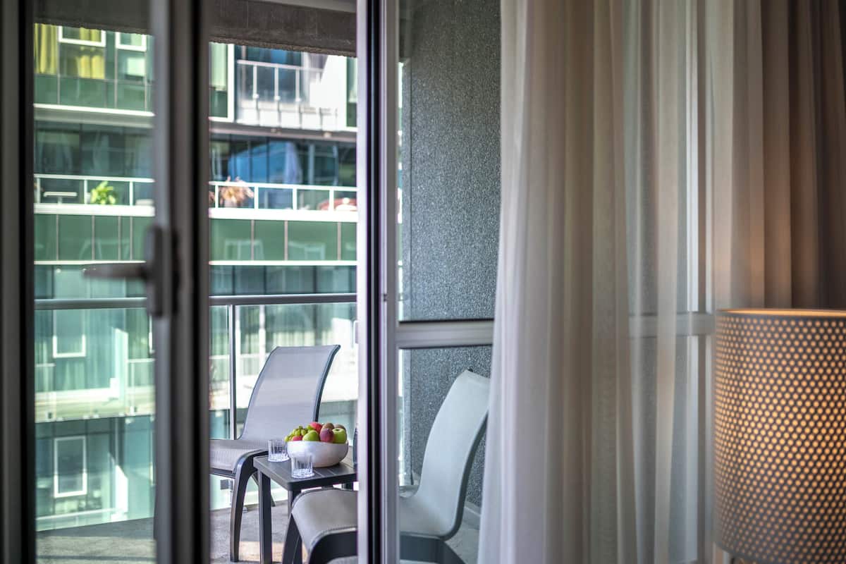 Un balcón con una mesa, sillas y un frutero.