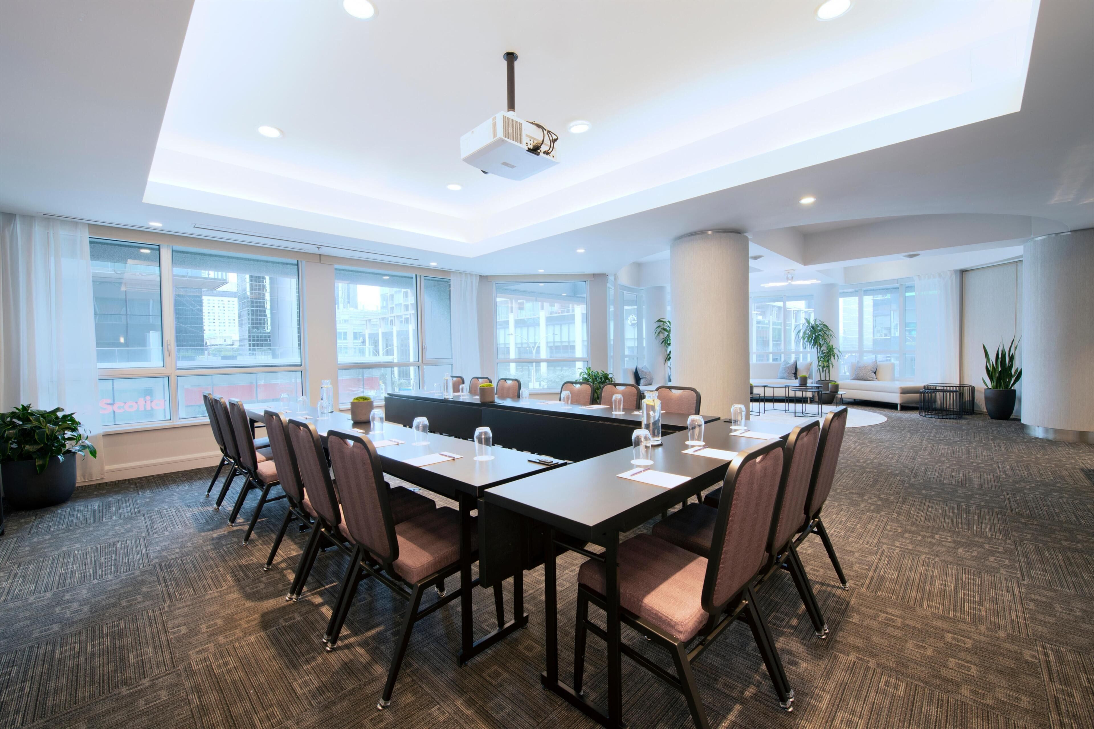 A conference room with a long table, chairs, and a projector.