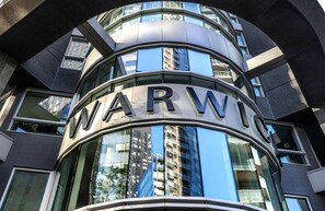 A building with a curved facade and the letters 'WARW' prominently displayed. - Warwick Le Crystal - Montréal (Montreal)