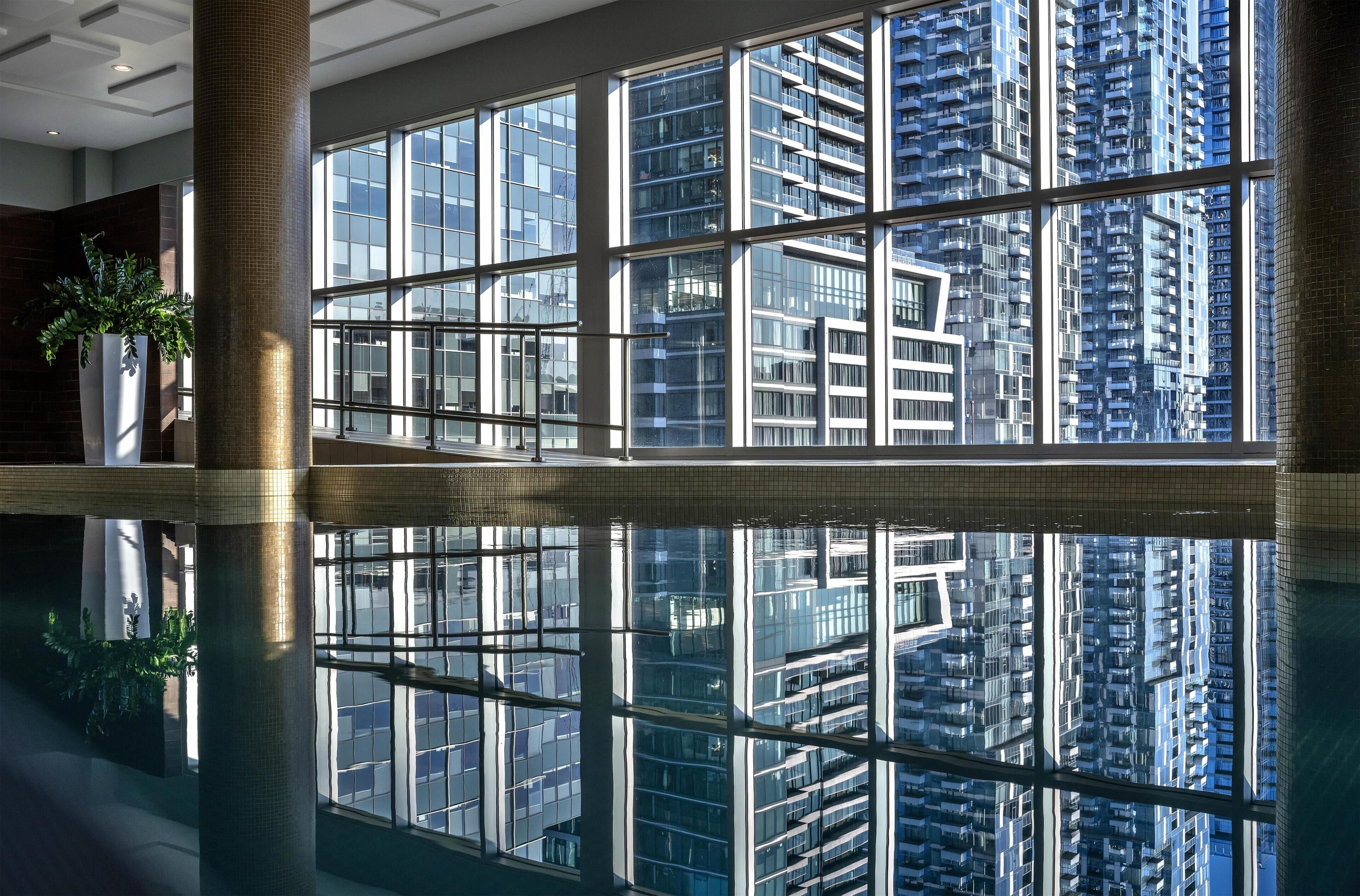 A modern interior with large windows reflecting a high-rise building.