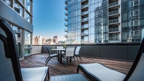 Ein moderner Außenbereich mit Holzterrasse, Metallstühlen und einem Tisch.
