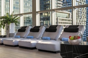 A rooftop lounge area with sun loungers, a potted plant, and a fruit bowl. - Warwick Le Crystal - Montréal (Montreal)