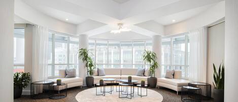 A spacious living area with a large window, a round coffee table, and a sofa.