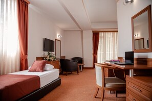 A hotel room with a bed, a desk, a chair, a TV, and a mirror. - Hotel Drim (Struga)