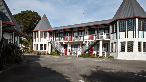 A building with a symmetrical facade, multiple windows, and a central staircase leading to an upper level.