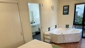 Un baño moderno con una bañera grande, un lavabo y un espejo.