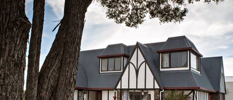 A two-story building with a gabled roof, large windows, and stone accents.