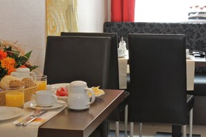 Una mesa con sillas y vistas por la ventana para el desayuno.