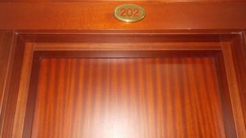 A wooden door with a brass plaque reading "202".