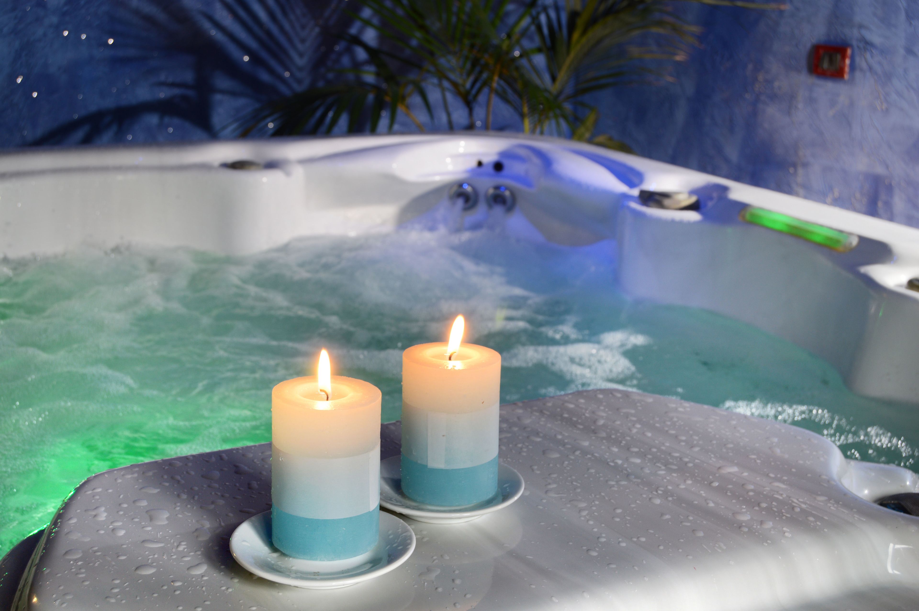 Ein Whirlpool mit zwei Kerzen auf einer nassen Fläche.