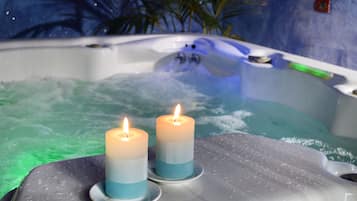 Ein Whirlpool mit zwei Kerzen auf einer nassen Fläche.