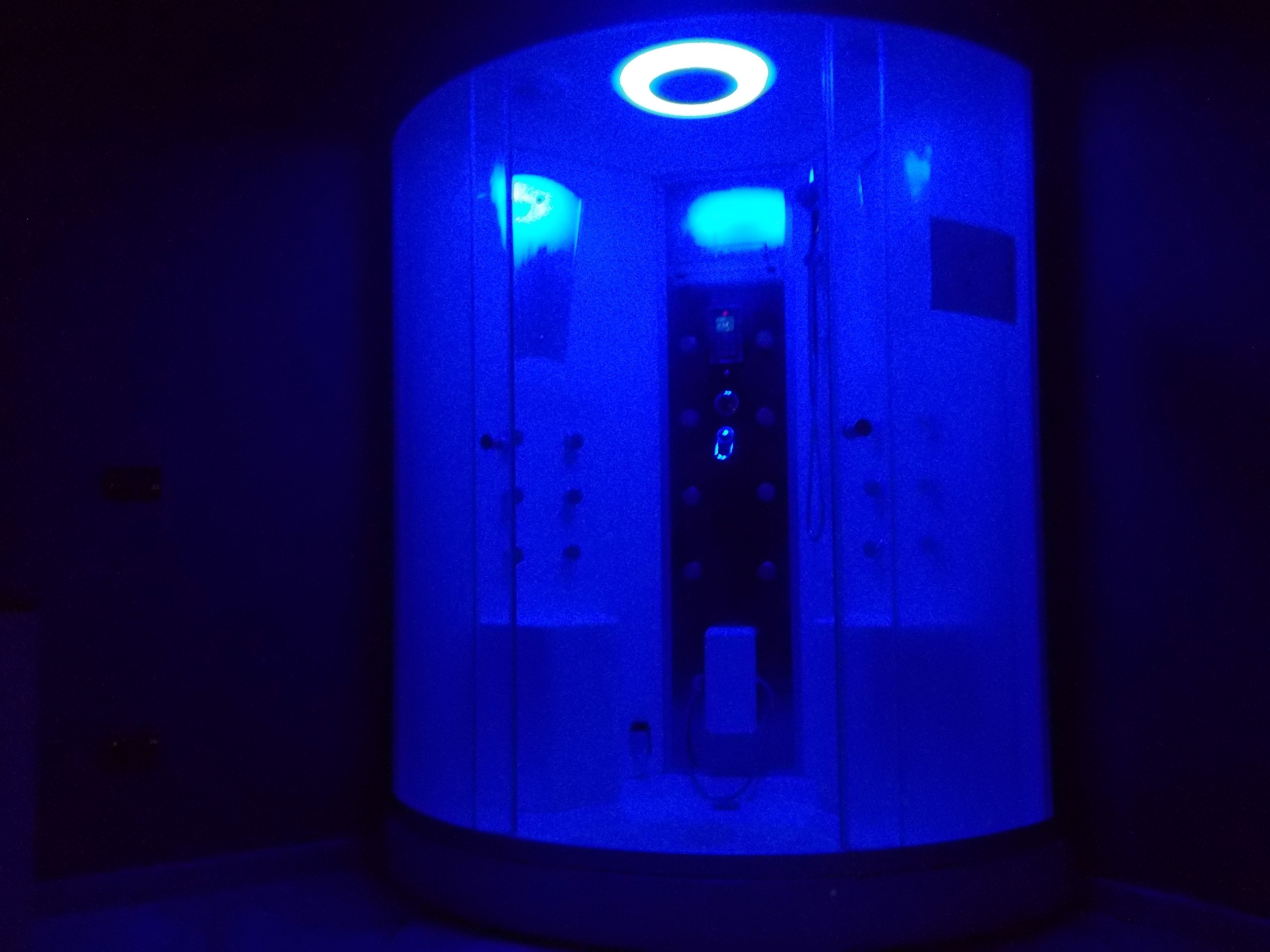 Une structure cylindrique surmontée d’une lumière circulaire, dotée d’une porte avec une poignée et d’un panneau de commande avec des boutons.