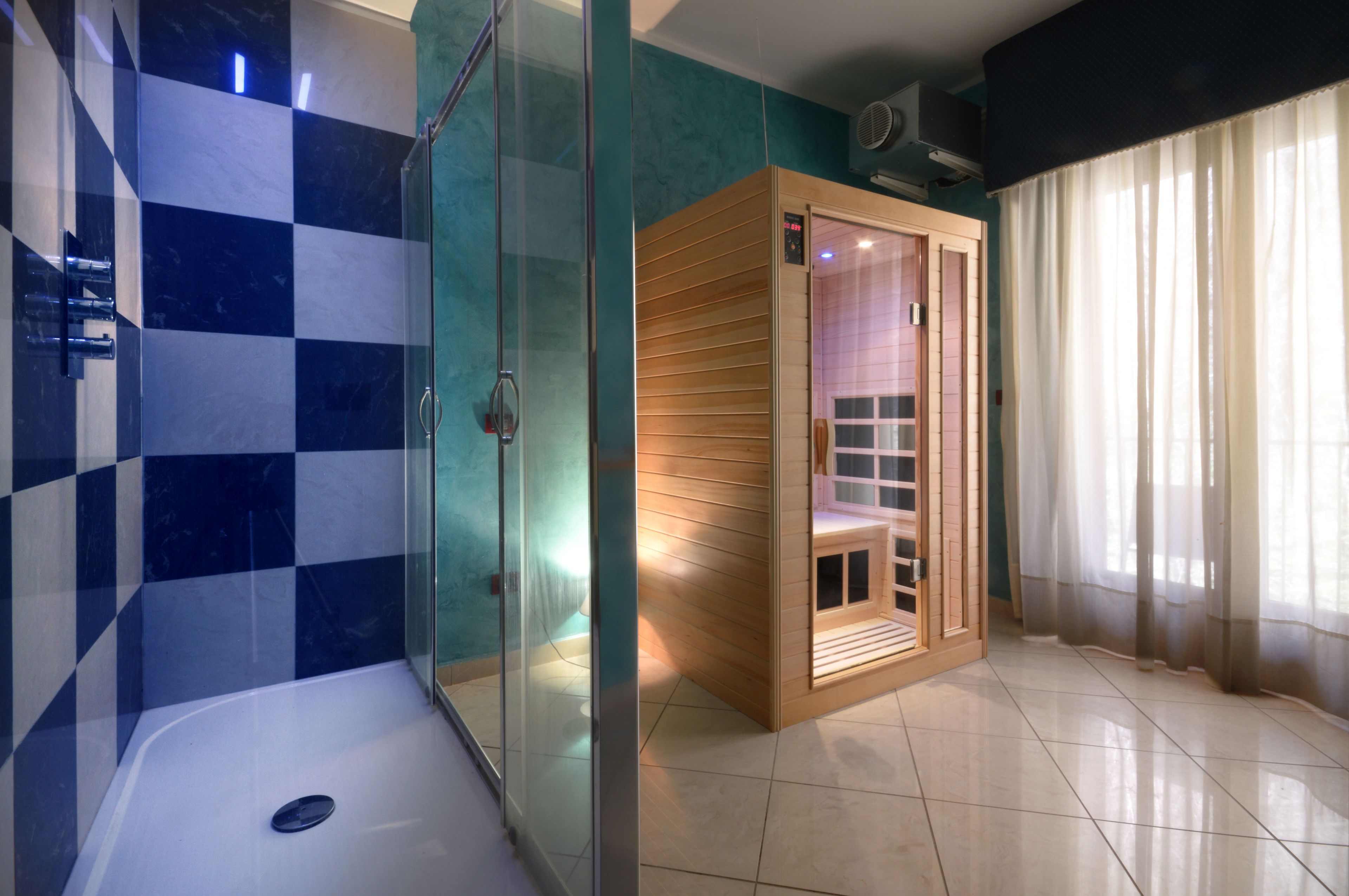 Une salle de bain moderne avec une douche à parois de verre, un sauna en bois et une baignoire.