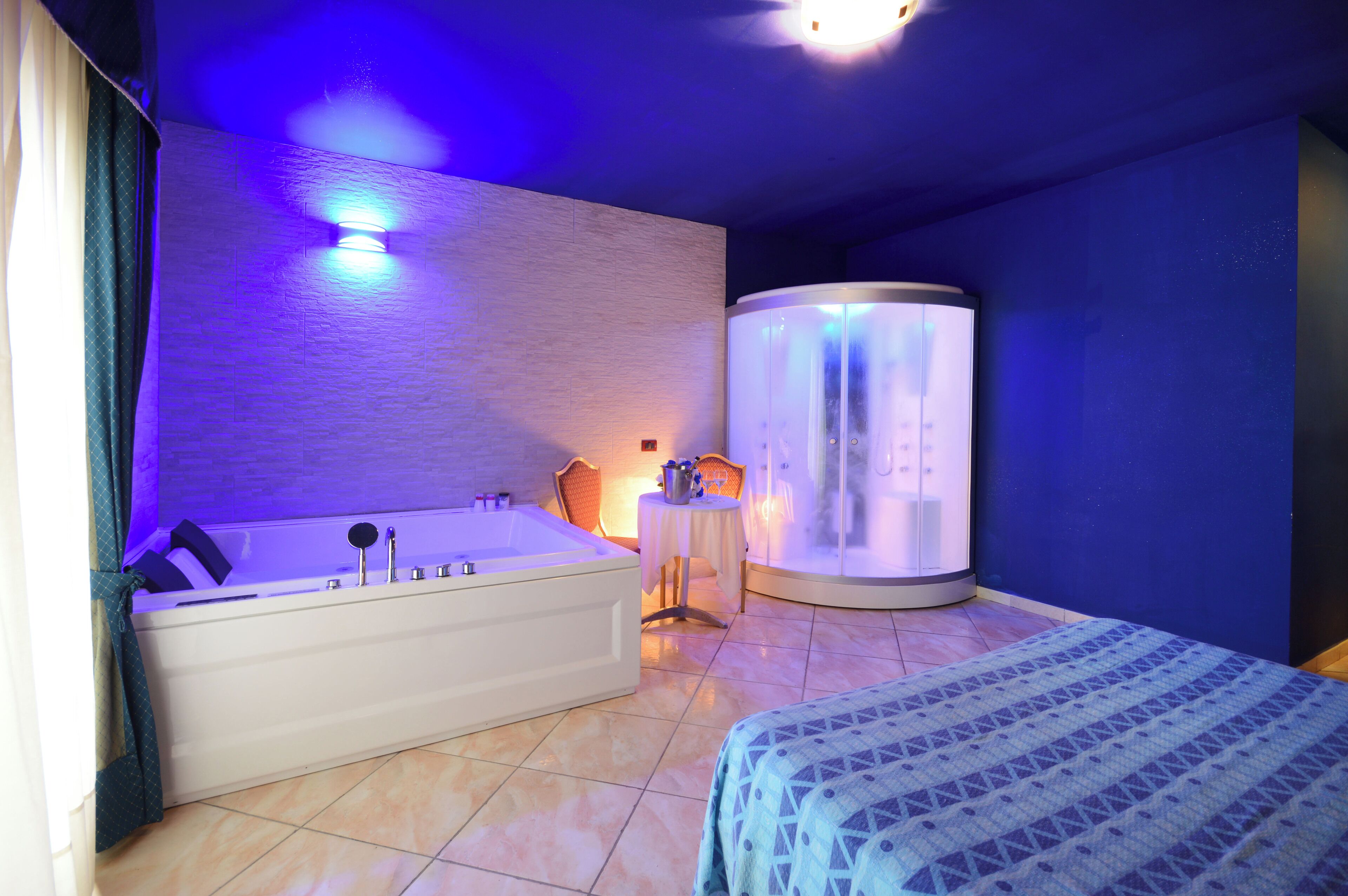 Un baño moderno con bañera, sillón de masaje y ducha de vapor.