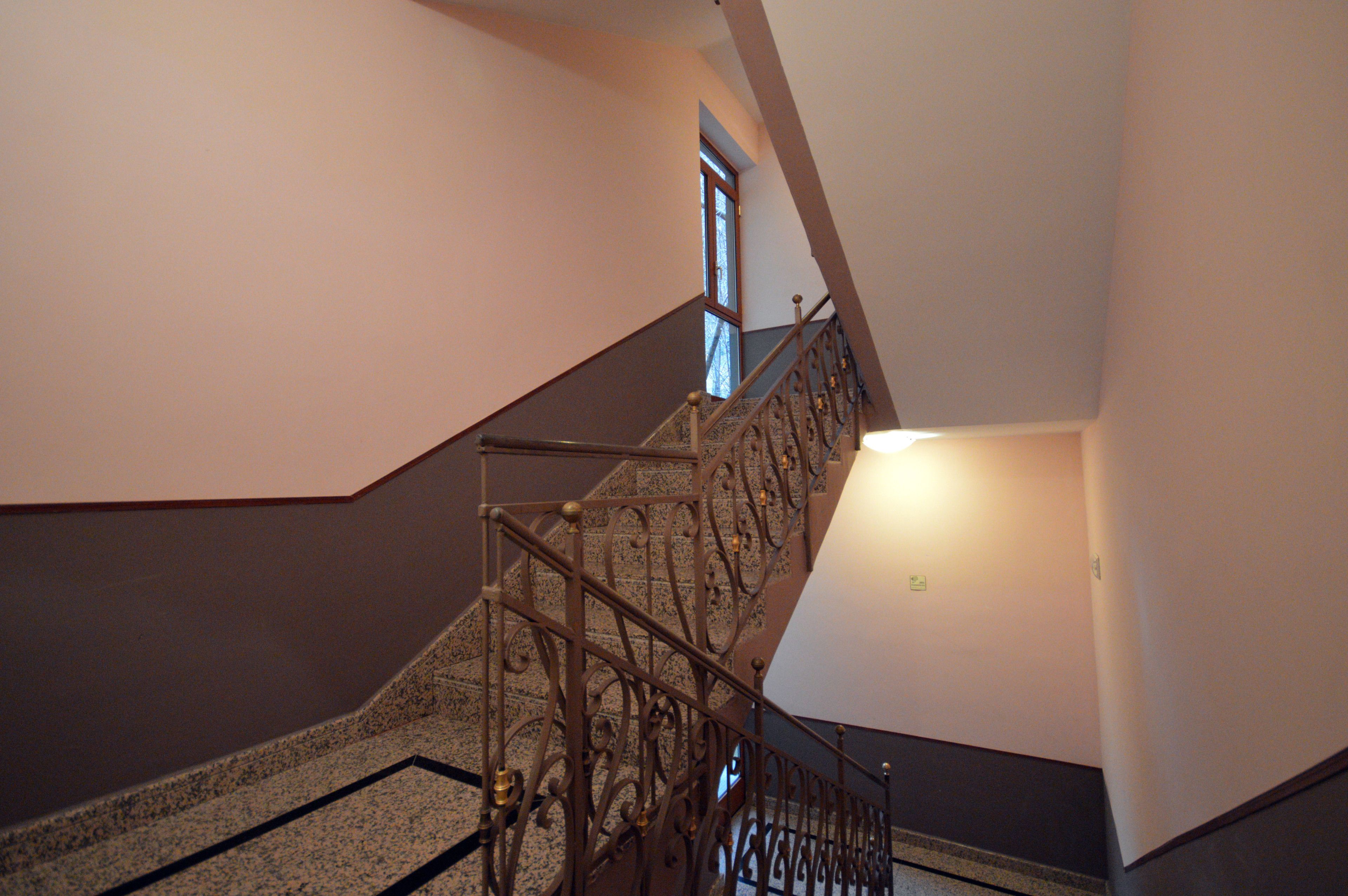 Eine Treppe mit aufwendiger Metallgeländerung und einem Teppichbelag.