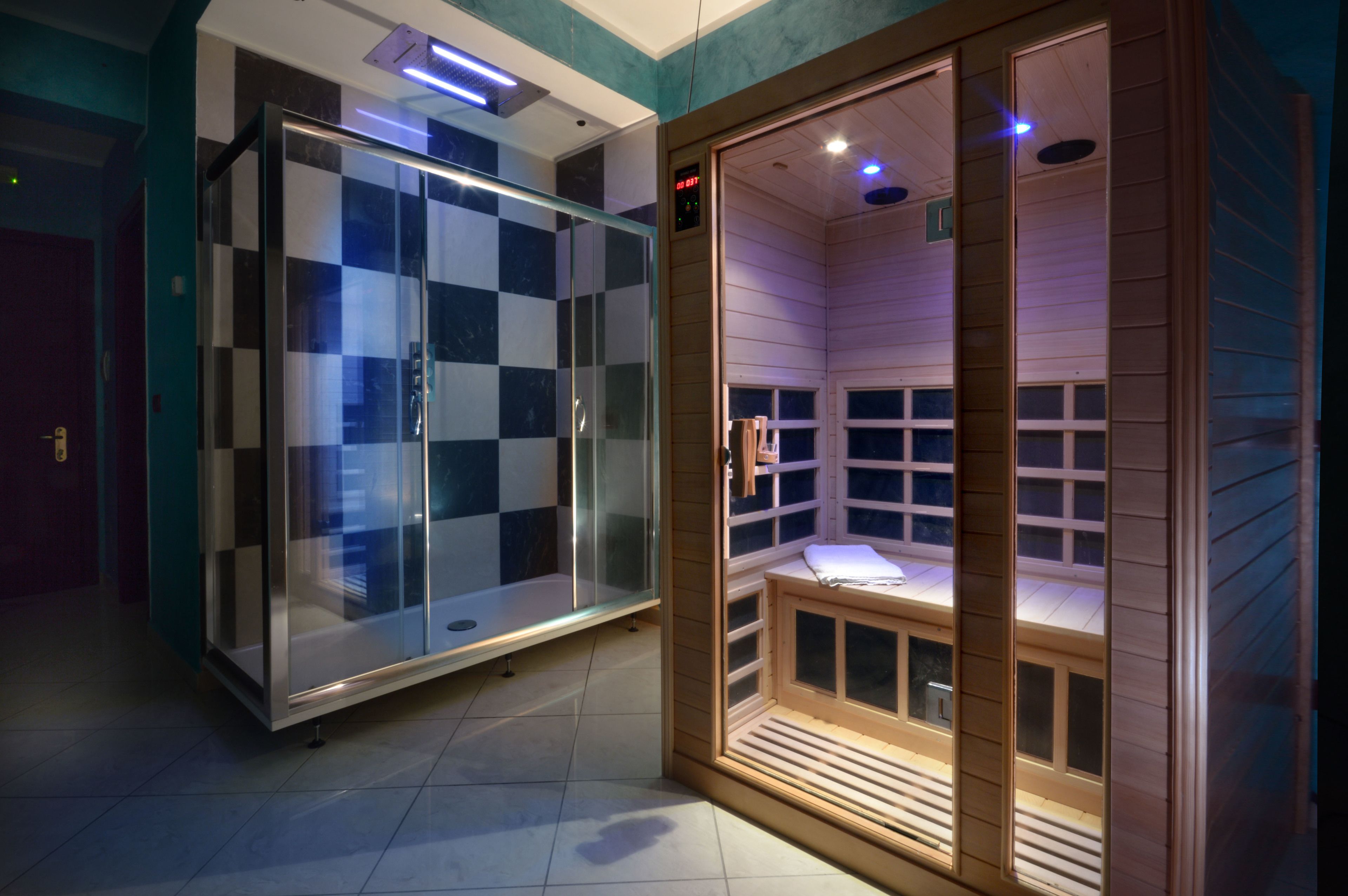Un sauna con puertas de vidrio y un banco de madera.