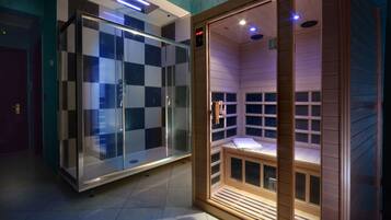 Un sauna con puertas de vidrio y un banco de madera.