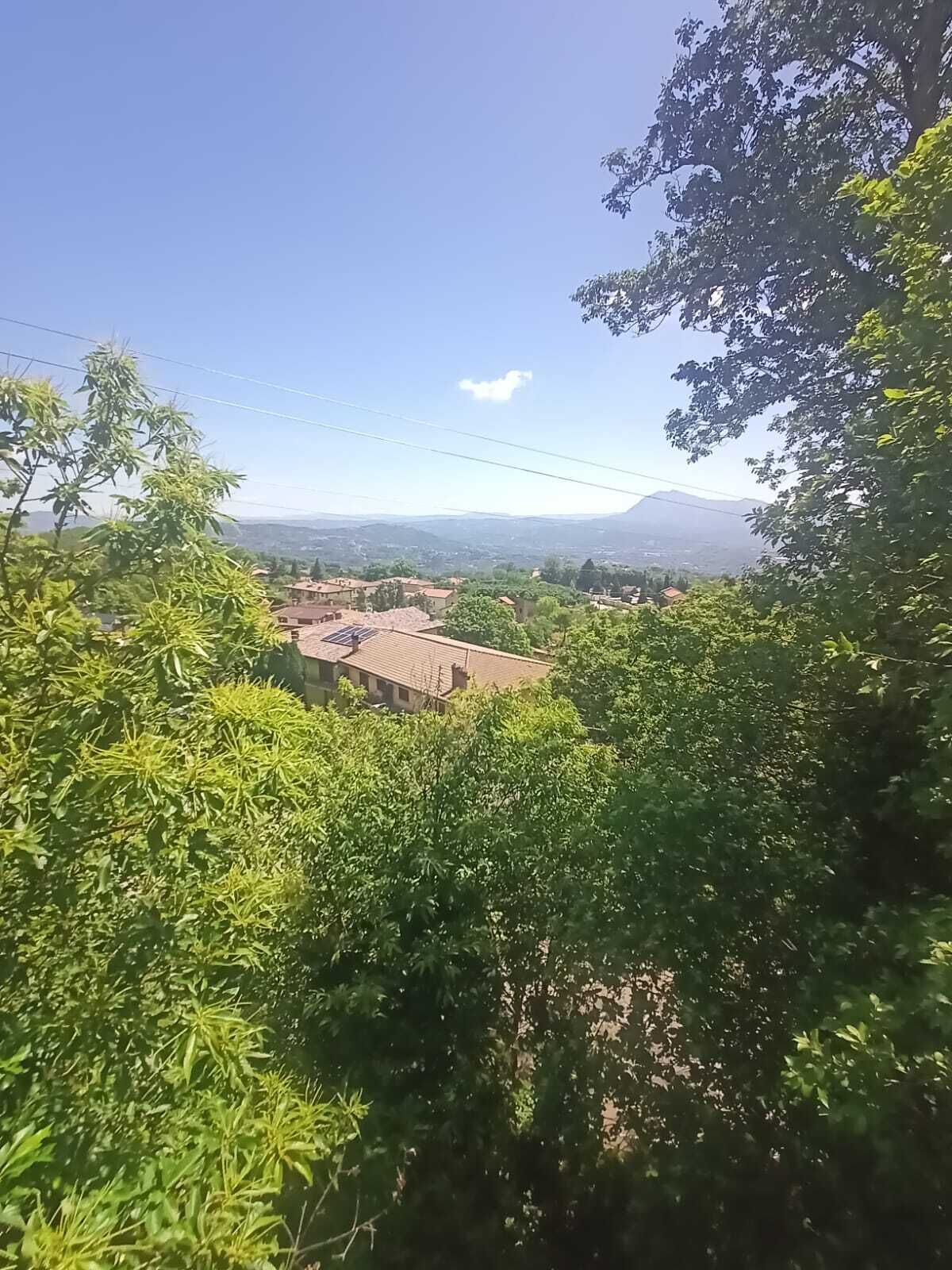 A view of a rural landscape with houses and trees.