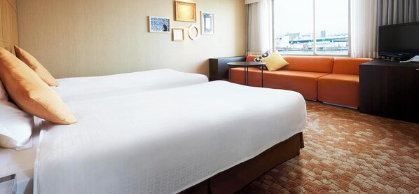 A hotel room with a bed, a sofa, a small table, and a TV. - HOTEL UNIVERSAL PORT (Osaka)