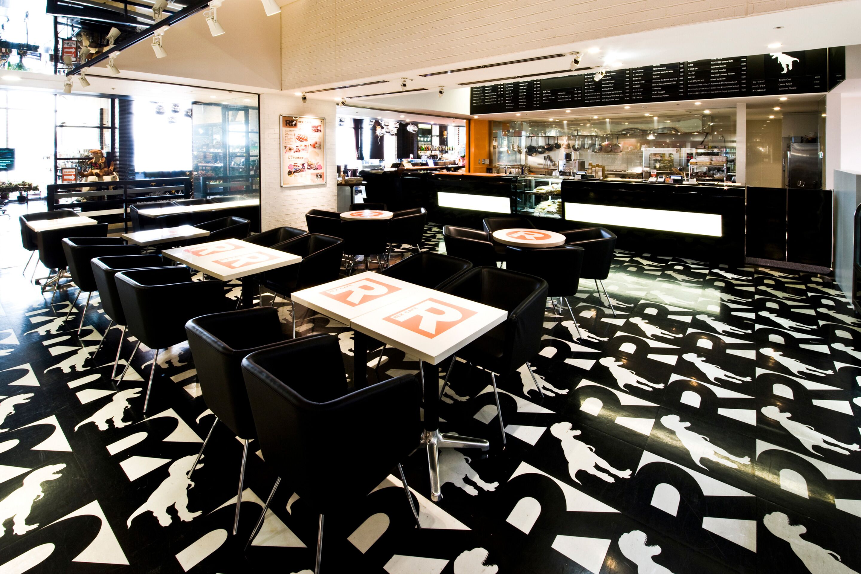 A restaurant with black and white patterned flooring, tables with 'BR' signs, and a bar area in the background.