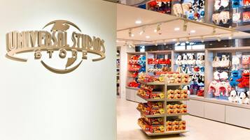 A Universal Studios Store with a prominent sign, shelves stocked with plush toys, and a display of Spider-Man merchandise.