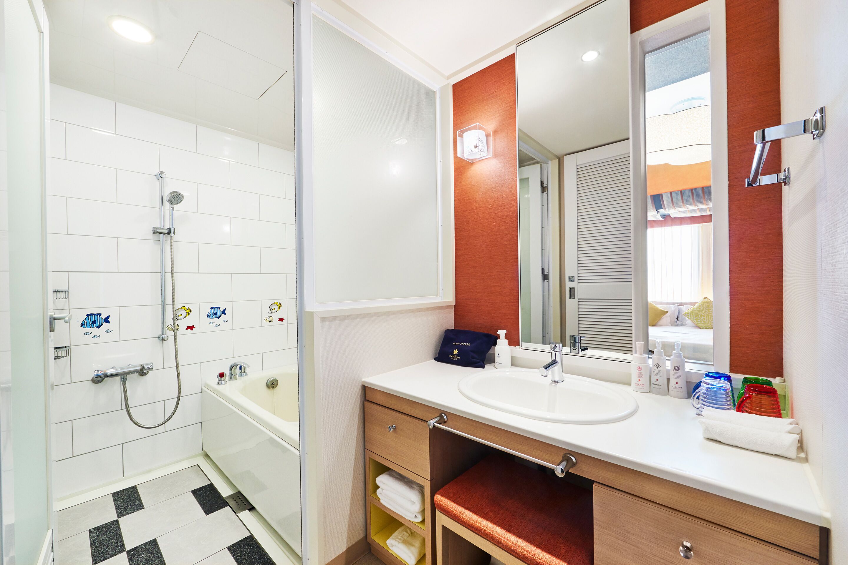 A bathroom with a white sink, mirror, and shower. There are toiletries on the sink and a towel rack.