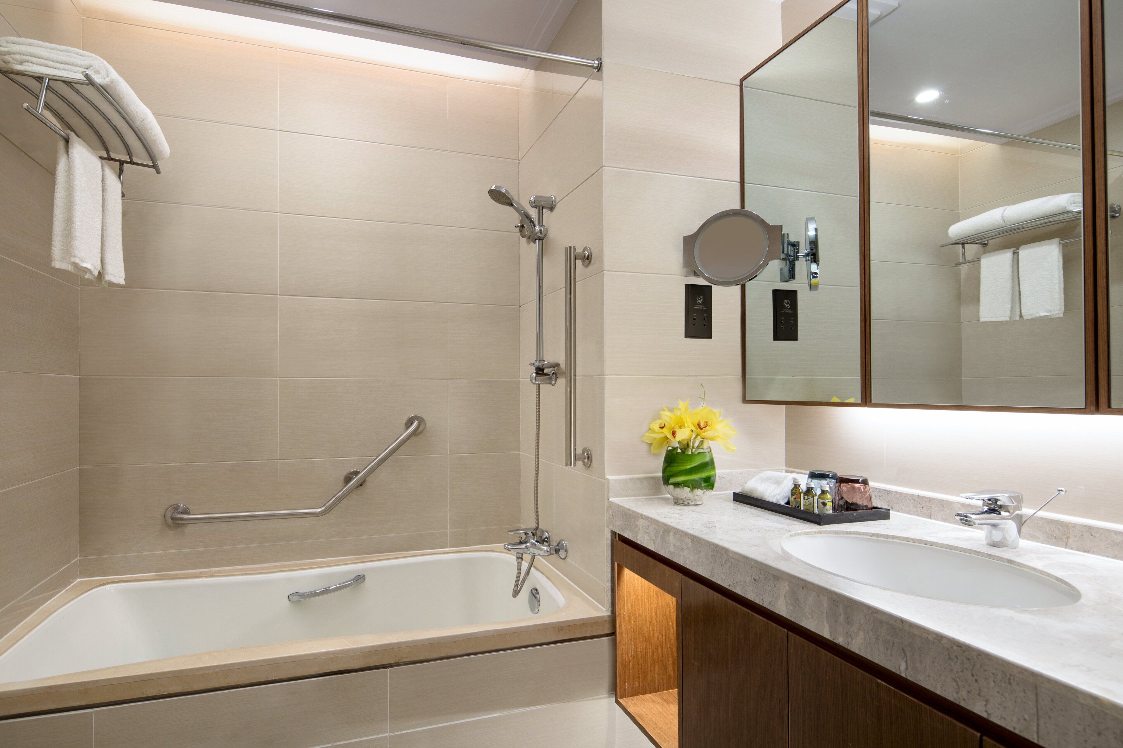 Un baño moderno con bañera, ducha y tocador con espejo.