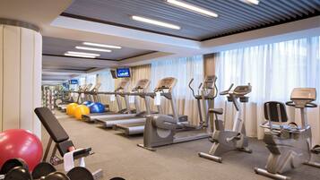 Ein Fitnessstudio mit Laufbändern, Crosstrainern und Kurzhanteln.