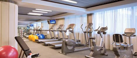 A gym with treadmills, elliptical machines, and free weights.