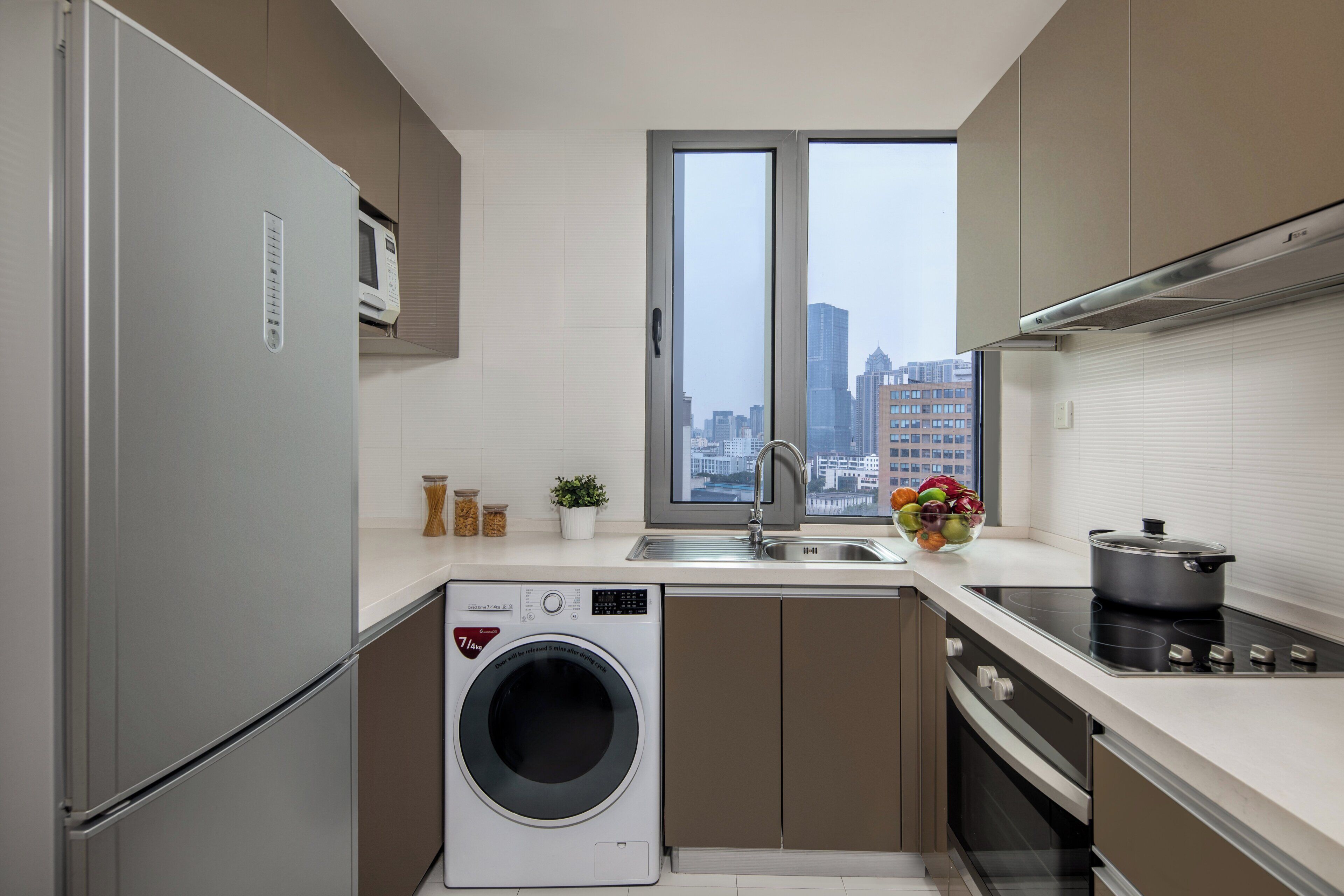 A modern kitchen with a built-in washer, a sink, and a stove.