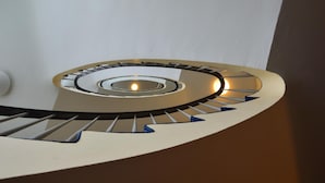 A spiral staircase with a central light fixture. - Hotel Mercedes Hamburg (Hamburg)