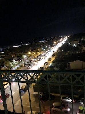 A nighttime view of a busy street with cars and buildings. - Arianna Hotel (Pietrasanta)