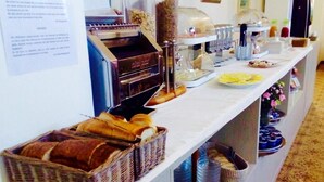 Ein reichhaltiges Buffet mit Brokkörben, einer Kaffeestation und einer Auswahl an Speisen.
