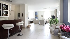 Ein modernes Wohnzimmer mit Barbereich, einer Sofagarnitur und einem Blumentopf.