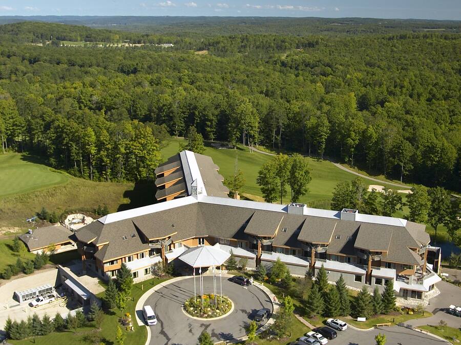 A large building with multiple parking lots and a golf course in the background.